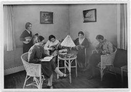 "Jungmädchenklub in Zürich" Zwei Frauen sitzend mit einem Instrument in der Hand, zwei Frauen sitzend mit einem Buch in der Hand und eine Frau stehend mit einem Instrument in der Hand, um 1930