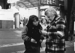 Mitarbeiterin der Freundinnen junger Mädchen beim Auskunftgeben am Bahnhof, 1981