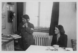 Zwei Frauen in einem Raum, eine Frau stehend am Telefon, zweite Frau sitzend, um 1950