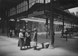 Drei Frauen am Bahnhof stehend, um 1910