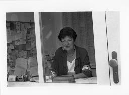 Eine Frau der SOS Bahnhofhilfe an einem Schriebtisch arbeitend, um 1990