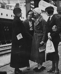 Vier Frauen am Bahnhof stehend, eine Frau einer evangelischer Bahnhofshilfe, um 1930