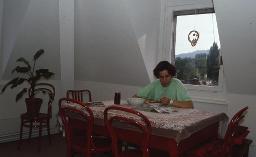 Töchterpension Mainau, Zürich, eine Frau am Tisch sitzend, am essen und lesen, um 1980