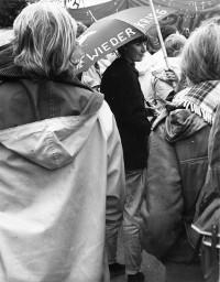 Friedensdemonstration: eine Frau trägt einen Regenschirm mit der Aufschrift "Nie wieder Krieg"