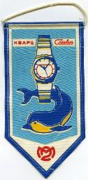 Blauer Wimpel mit der Aufschrift Craba (vermutlich eine Marke) und Quarz (in kyrillischer Schrift) und der Illustration einer Armbanduhr und eines Delfins