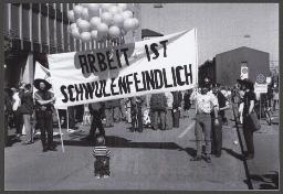1. Mai Demo (01.05.1990, Zürich) – "Arbeit ist schwulenfeindlich", Kleinkind betrachtet das Transparent