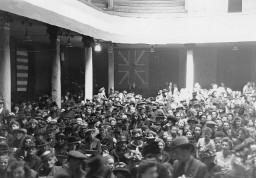 "St. Etienne. 26. Mai 1945. Jahrestagfeier der Bombardierung in der Bourse du Travail. St. Etienne. 26. Mai 1945. Anniversaire du bombardement à la Bourse du Travail" ; Zahlreiche Personen feiern die Jahrestagfeier der Bombardierung im Gewerkschaftshaus