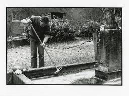 Auftragsvermittlungsstelle "Etcetera" in Zürich, Mann mit Besen bei einer Brunnen-Reinigung, Januar 1993