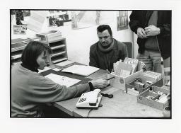 Auftragsvermittlungsstelle "Etcetera" in Zürich, eine Mitarbeiterin mit Kartei-Kasten auf dem Schreibtisch und wartenden Klienten, Januar 1993