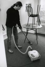 "Etcetera", Auftragsvermittlungstelle Bern, ein junger Mann beim Staubsaugen, 1999