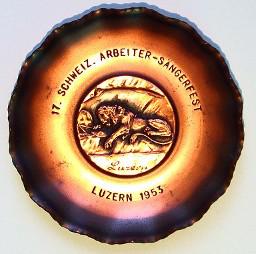 "17. Schweizerisches Arbeiter-Sängerfest, Luzern 1953" – Kupferfarbenes Ziertellerchen zur Teilnahme am Anlass des Schweizerischen Arbeitersänger-Verbandes in Luzern, 1953; Reliefbild eines schlafenden Löwen mit Schweizerwappen.