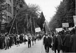 "Arbeiter Jugend fordert: den 8 Stunden Tag, den freien Samstag Nachmittag, ? Wochen Ferien"; die sozialistische Jugend mit Fahnen am 1. Mai-Umzug in Zürich,1. Mai 1930