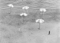 Sonnenschirme am Strand, ein Junge vorbeischlendernd