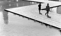Mann und Frau auf Holzpier laufend
