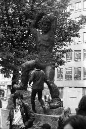 "Wohnungsdemo Werdplatz" - Einige Jugendliche, die sich auf dem Platz unterhalten; im Hintergrund die Skulptur 'Prometheus' von Werner F. Kunz, 01.10.1980