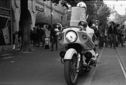 "Demo Bahnhofstrasse" - Strassenszene an der Bahnhofstrasse mit zahlreichen Menschen und einem Polizeibeamten auf einem Motorrad, 04.10.1980