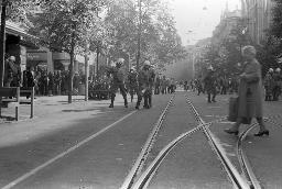 "Bahnhofstrassen-Demo / Einkreisung Pestalozziwiese" - Polizeibeamte beobachten das Geschehen in der Strasse, viele Zivilisten beobachten in der Nähe, 11.10.1980
