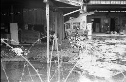 "AJZ" - Von der Polizei gesperrtes und verriegeltes autonomes Jugendzentrum beim Sihlquai, mehrere Menschen wischen mit Besen auf dem Gelände, 23.10.1980