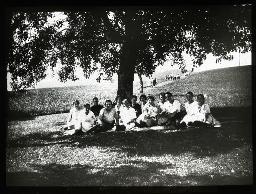 "Pensionärinnen auf einem Ausflug", Versammlung mehrerer junger Frauen unter einem Baum auf einer Wiese, um 1930