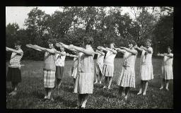 "Zürich, Neues Töchterheim", Mädchen auf einer Wiese mit einem Waldstück im Hintergrund, vermutlich am Ausführen von Turnübungen oder einer Choreografie, um 1930